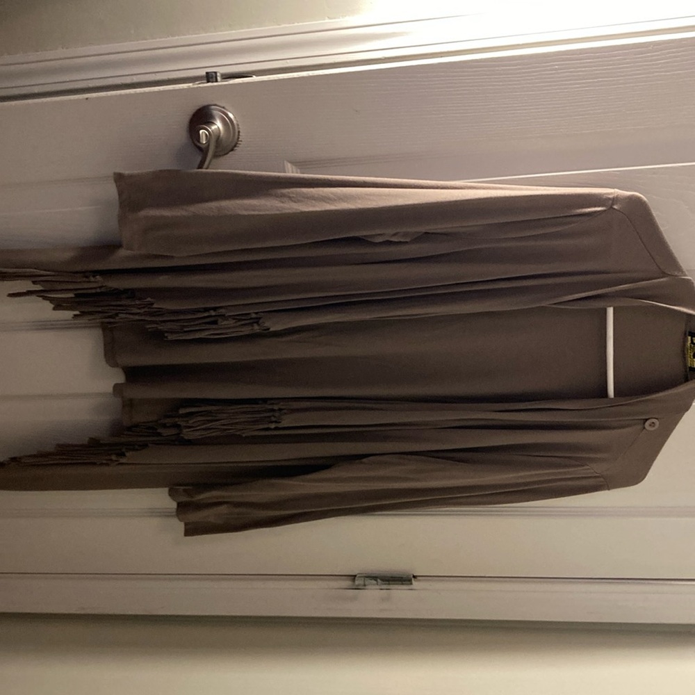 Size 1X tope color long sleeve has tassels on the bottom